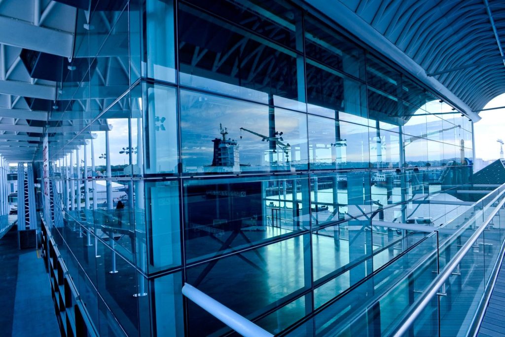 Contemporary glass building exterior reflecting urban landscape in Auckland, New Zealand.