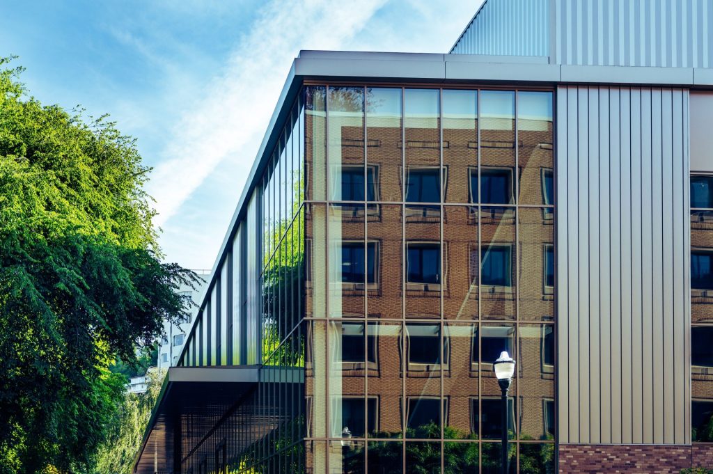 Contemporary building with reflective glass facade showcasing clear architectural lines and reflections.